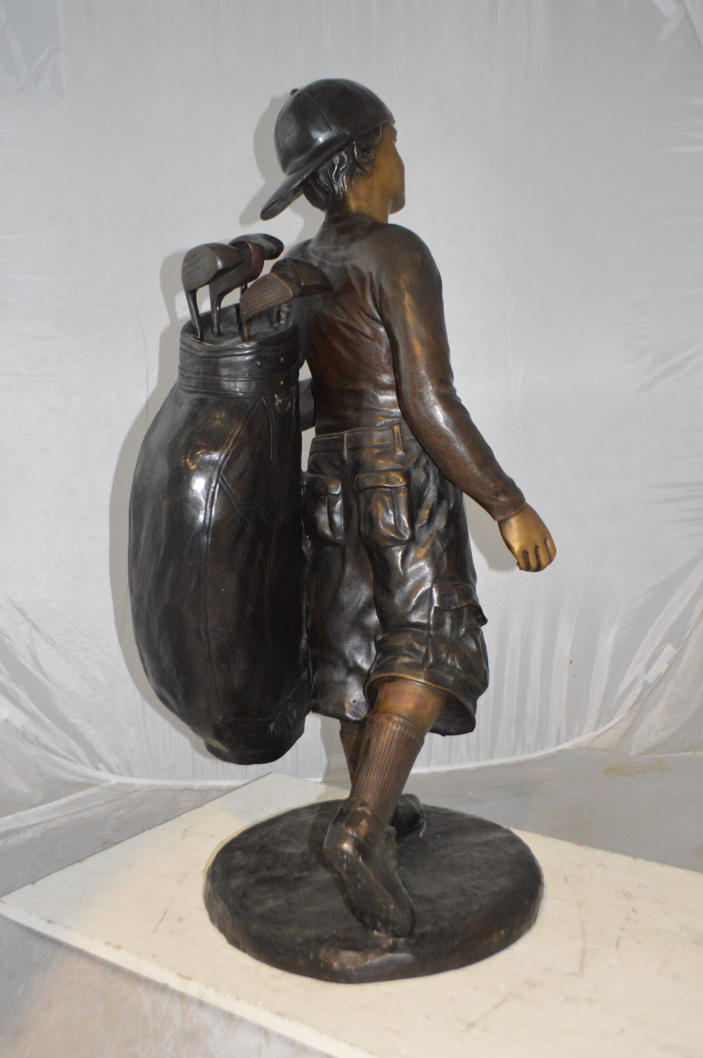 Boy Carrying A Golf Bag Bronze Statue - Size: 15"L x 15"W x 38"H.