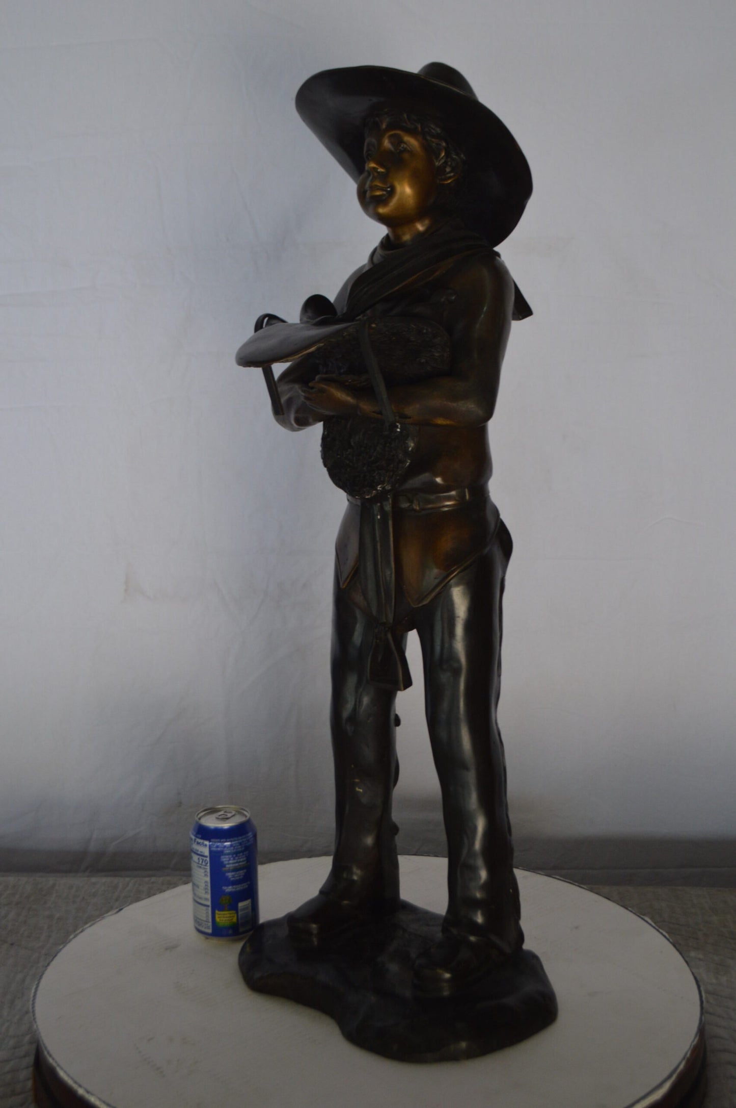 Cowboy Holding a Saddle Bronze Statue  -  Size: 12"L x 11"W x 32"H.