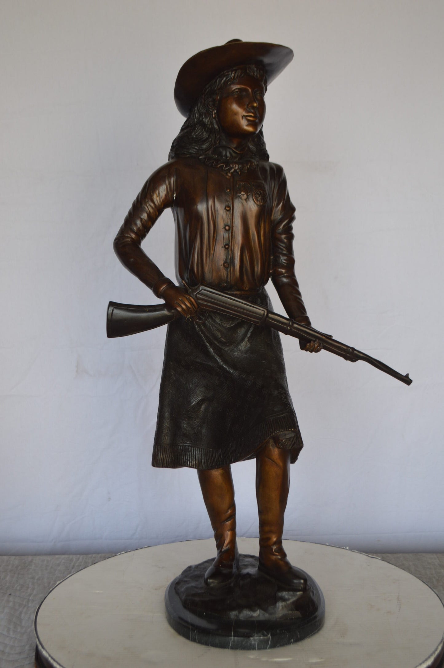 Annie Oakley Bronze Statue Mounted on a Marble Base - Size: 11"L x 9"W x 33"H.