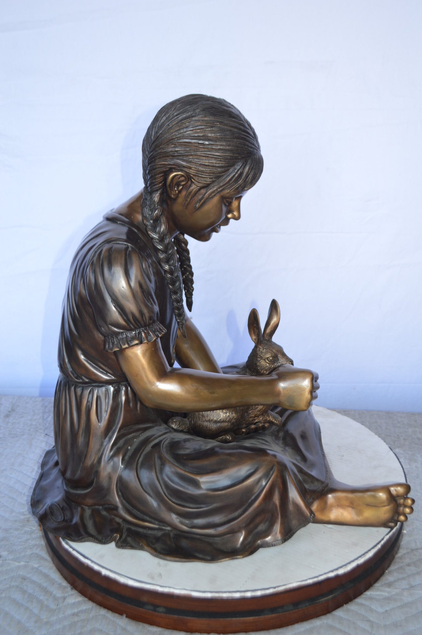 Sandra Sitting With Her Rabbit Bronze Statue - Size: 25"L x 18"W x 25"H.