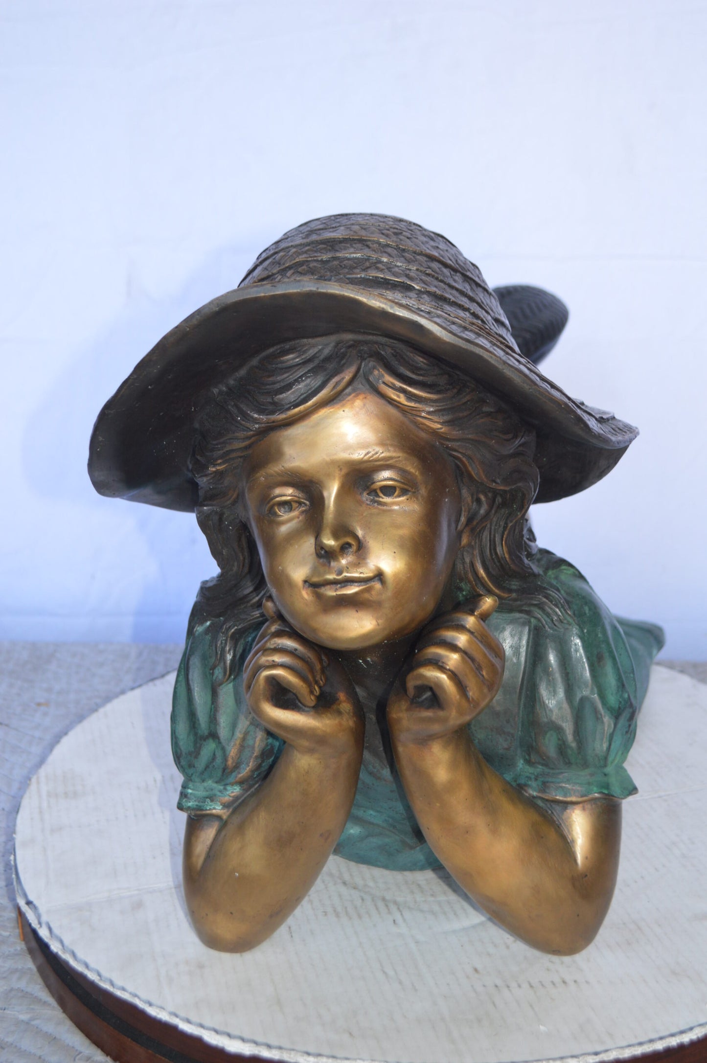 Girl Wearing A Hat Lying on Stomach Bronze Statue -  Size: 33"L x 17"W x 17"H.