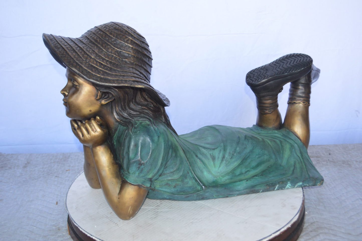 Girl Wearing A Hat Lying on Stomach Bronze Statue -  Size: 33"L x 17"W x 17"H.
