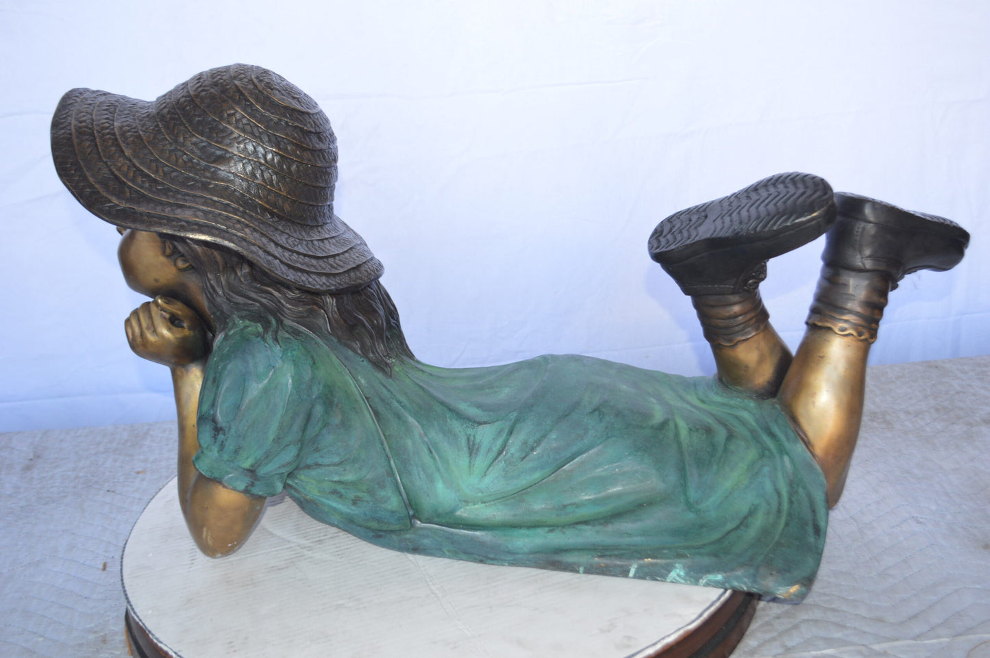 Girl Wearing A Hat Lying on Stomach Bronze Statue -  Size: 33"L x 17"W x 17"H.