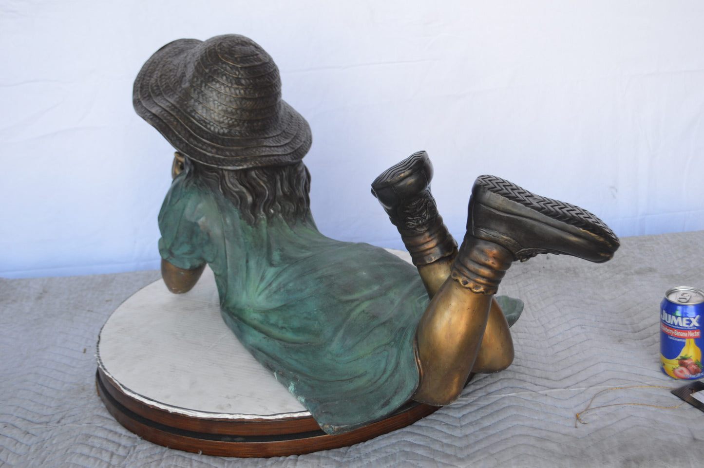 Girl Wearing A Hat Lying on Stomach Bronze Statue -  Size: 33"L x 17"W x 17"H.