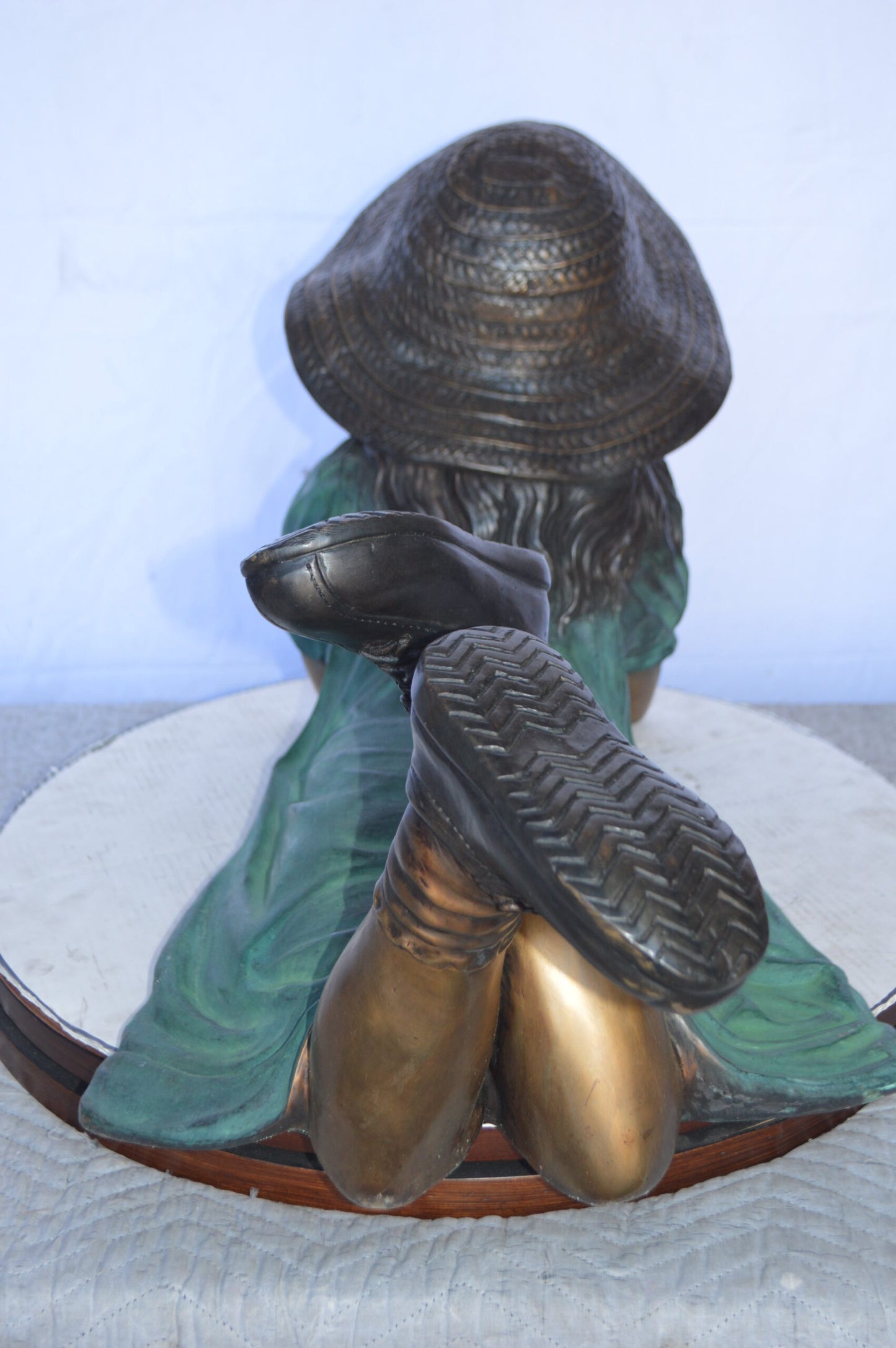 Girl Wearing A Hat Lying on Stomach Bronze Statue -  Size: 33"L x 17"W x 17"H.