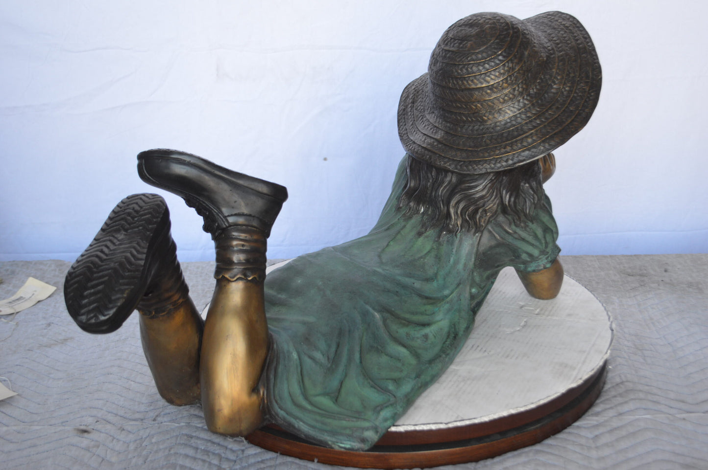 Girl Wearing A Hat Lying on Stomach Bronze Statue -  Size: 33"L x 17"W x 17"H.