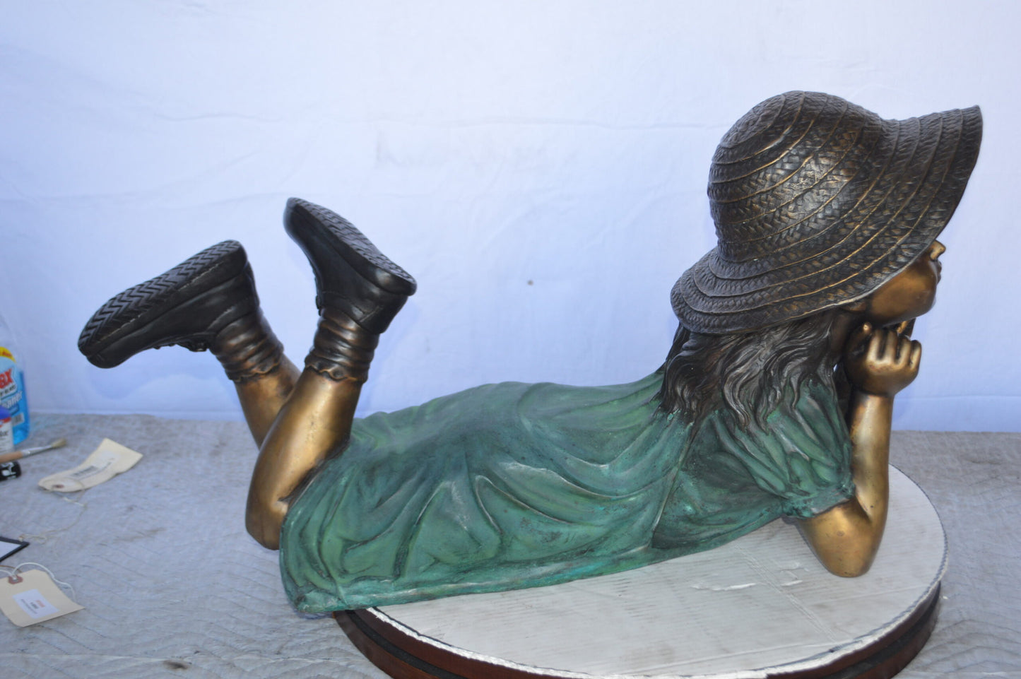 Girl Wearing A Hat Lying on Stomach Bronze Statue -  Size: 33"L x 17"W x 17"H.