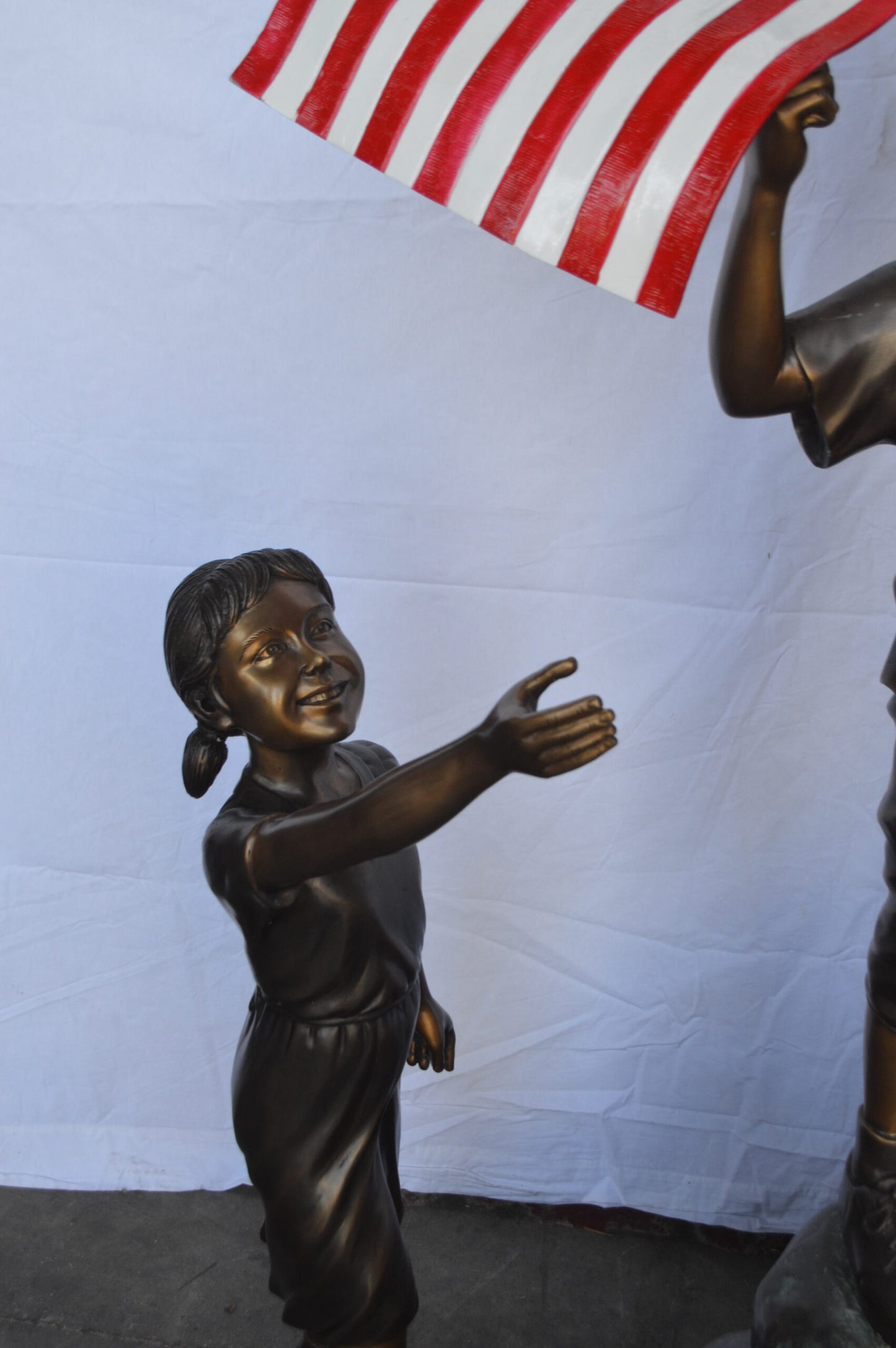 Two Kids on Rock W the American Flag Bronze Statue -  Size: 50"L x 22"W x 58"H.