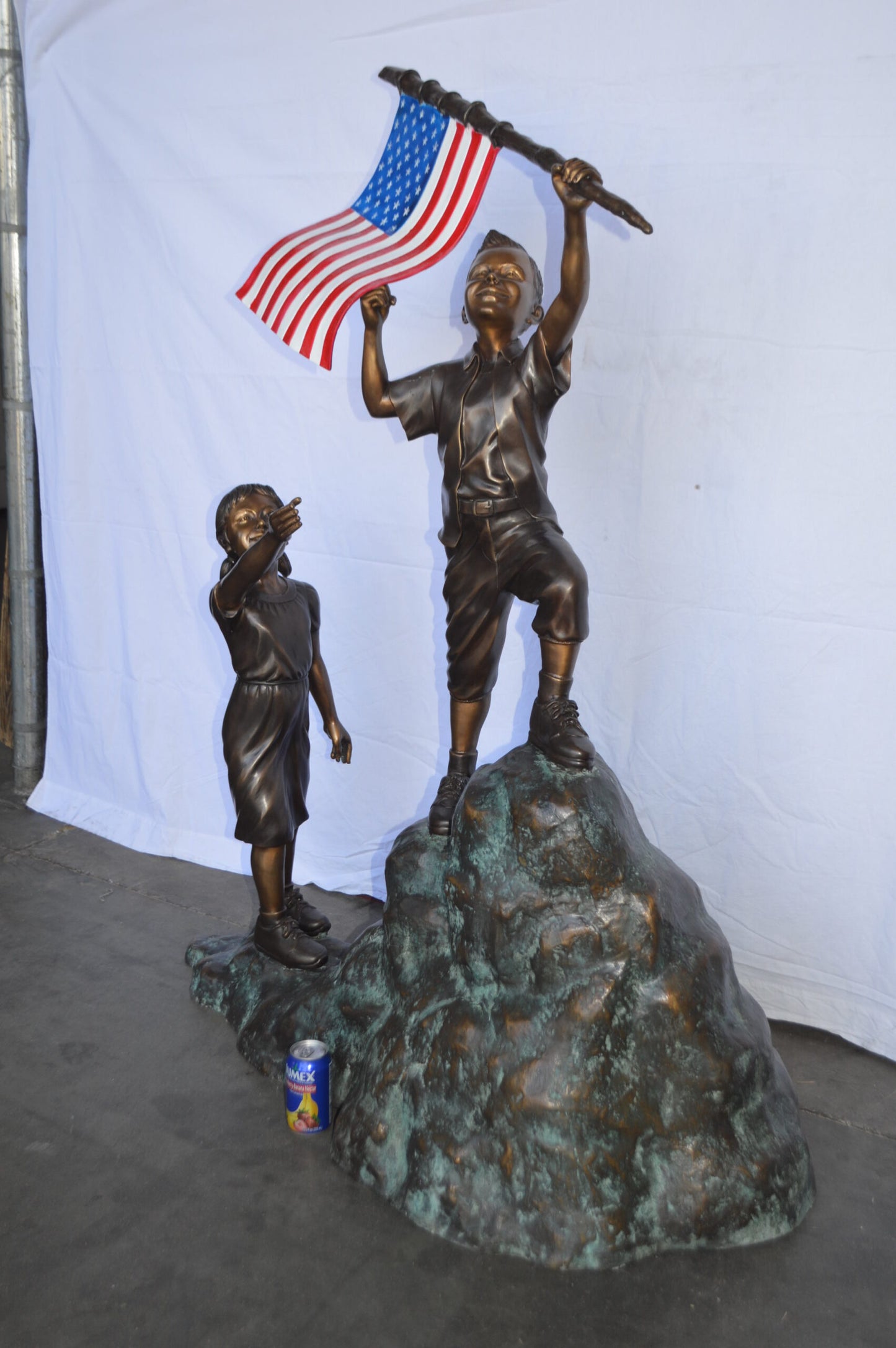 Two Kids on Rock W the American Flag Bronze Statue -  Size: 50"L x 22"W x 58"H.