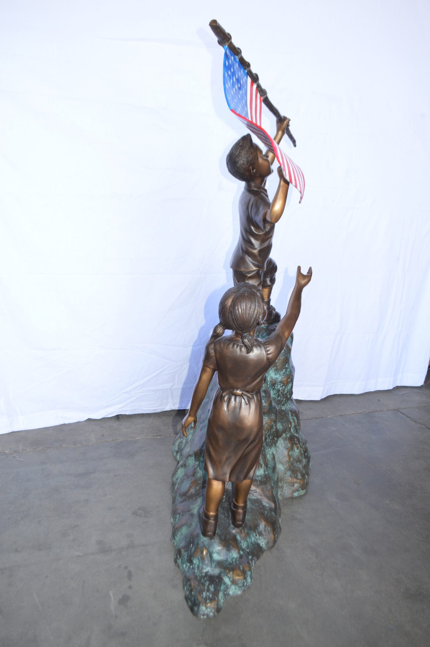 Two Kids on Rock W the American Flag Bronze Statue -  Size: 50"L x 22"W x 58"H.