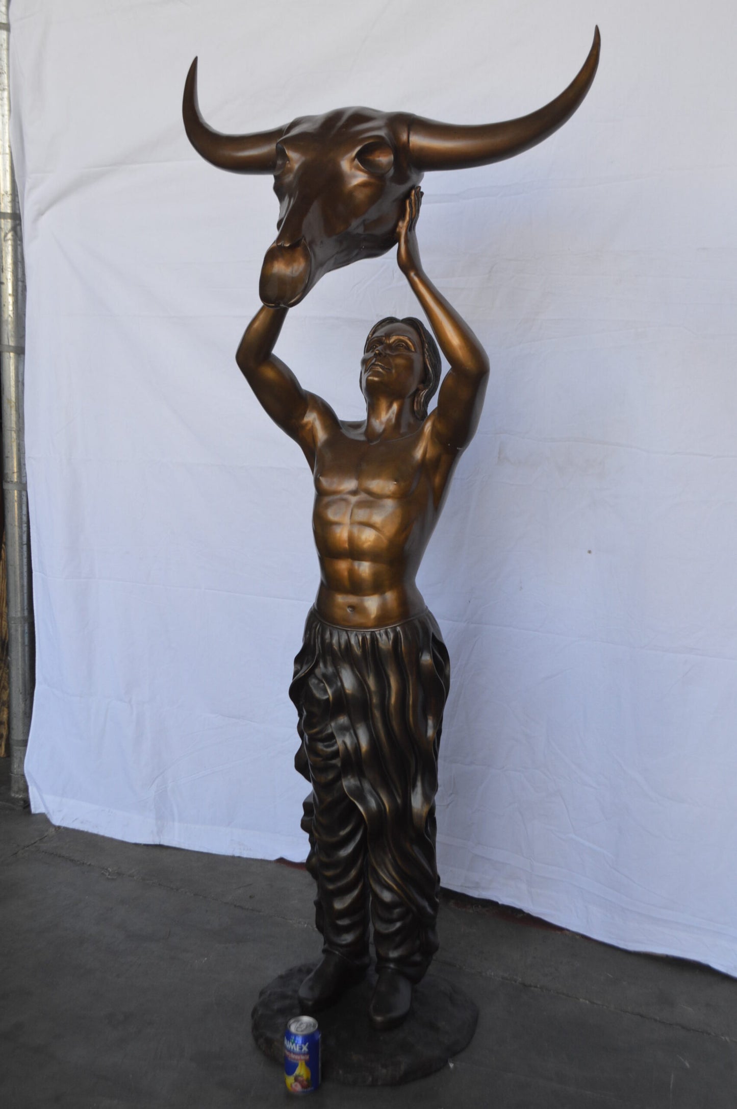 Indian Man Holds a Buffalo Skull Bronze Statue - Size: 29"L x 23"W x 72"H.