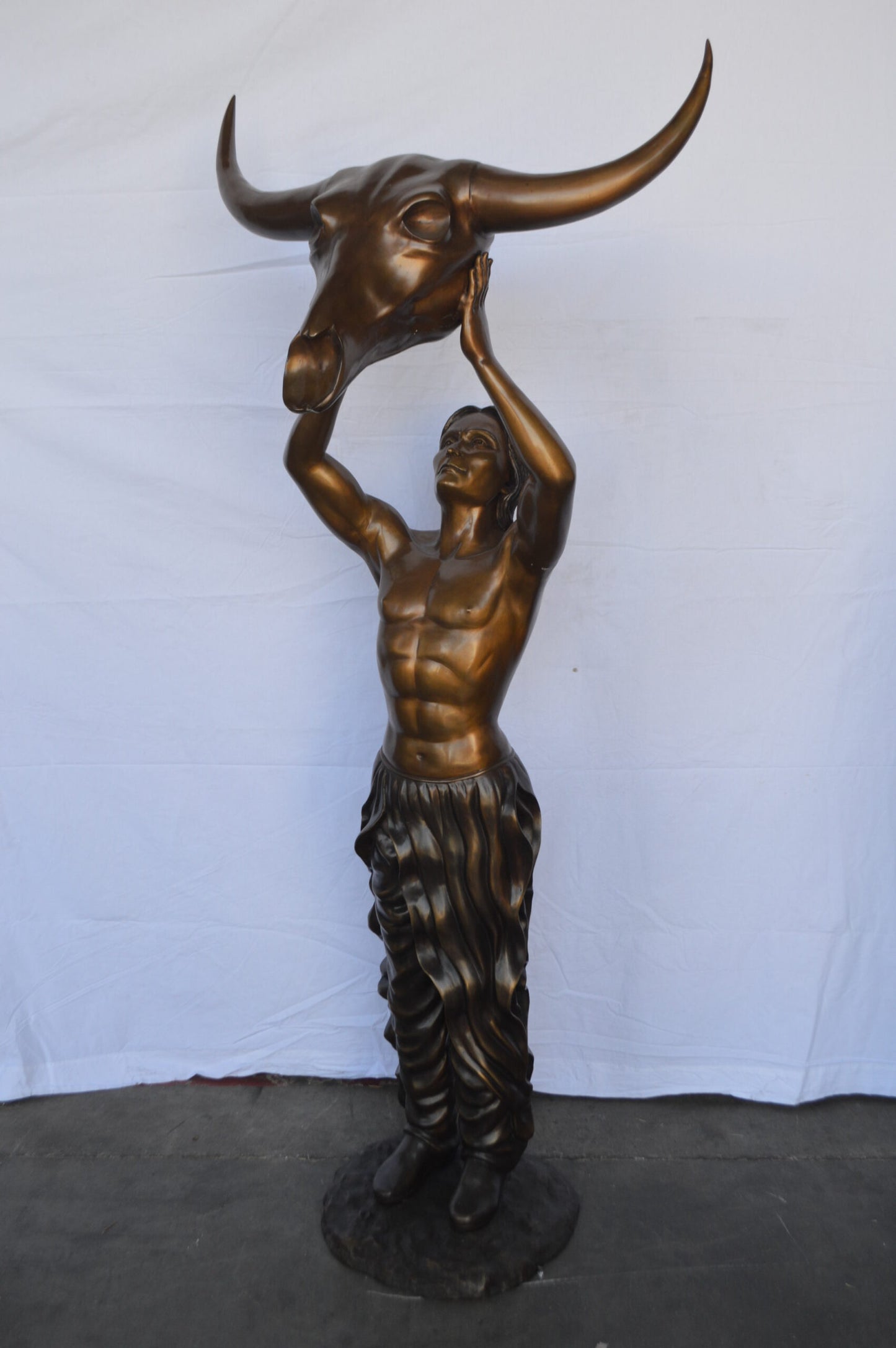 Indian Man Holds a Buffalo Skull Bronze Statue - Size: 29"L x 23"W x 72"H.
