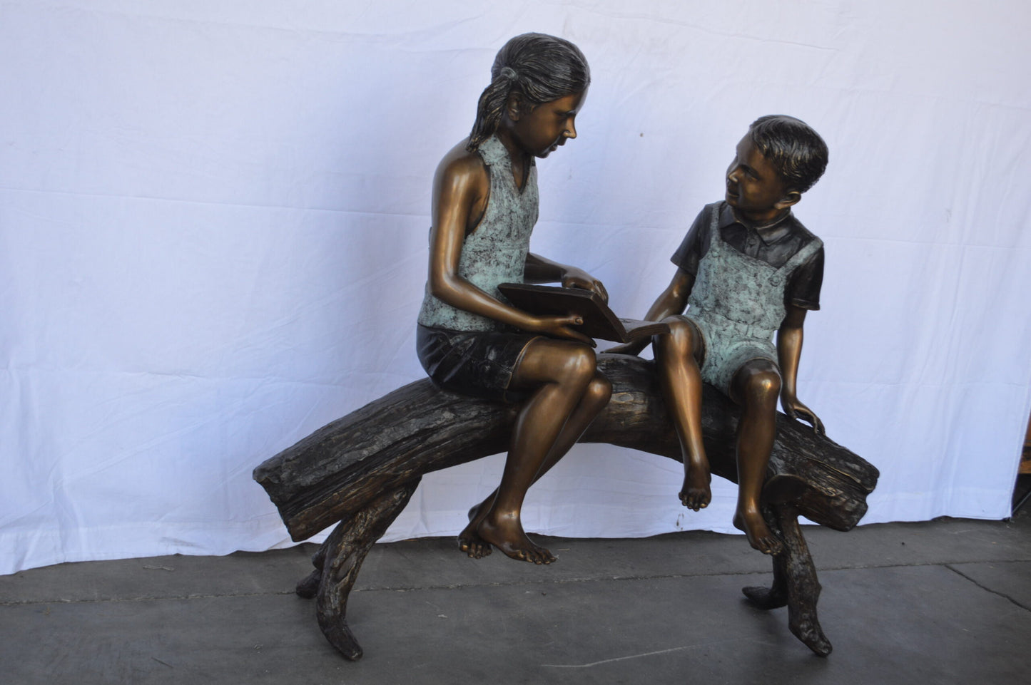 Two Kids on a tree log reading Bronze Statue Large -  Size: 44"L x 17"W x 42"H.