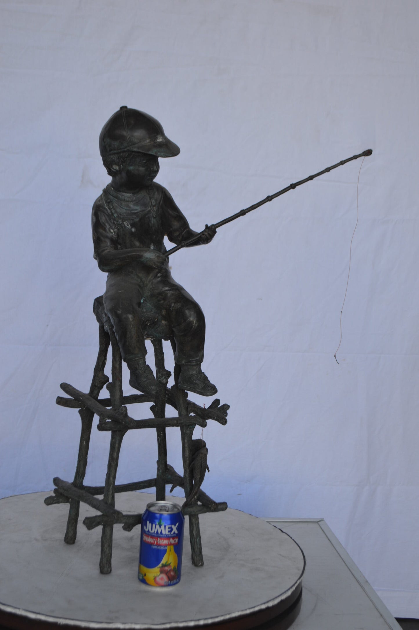 A Boy on a high Chair Fishing Bronze Statue - Size: 16"L x 14"W x 28"H.