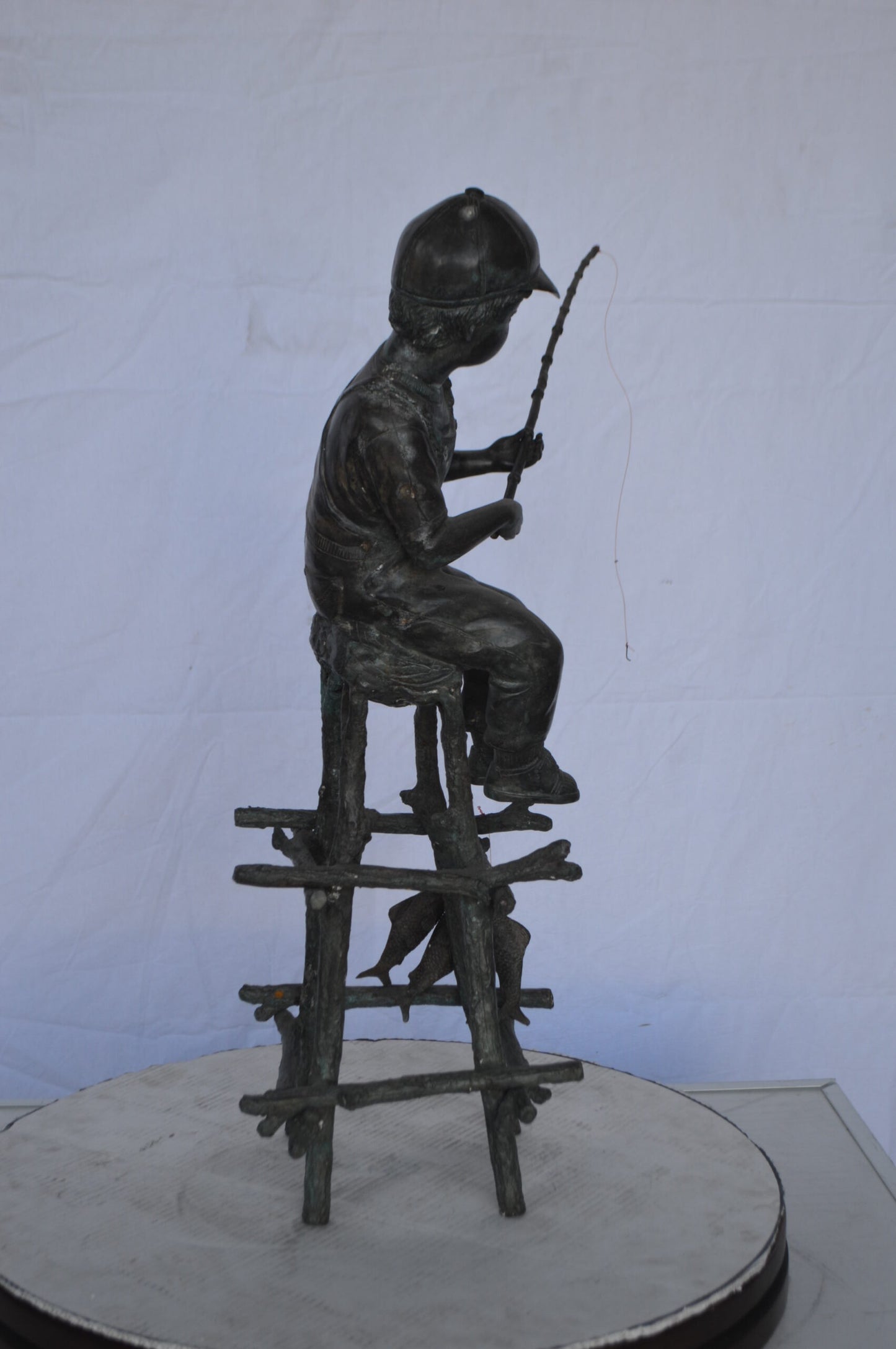 A Boy on a high Chair Fishing Bronze Statue - Size: 16"L x 14"W x 28"H.