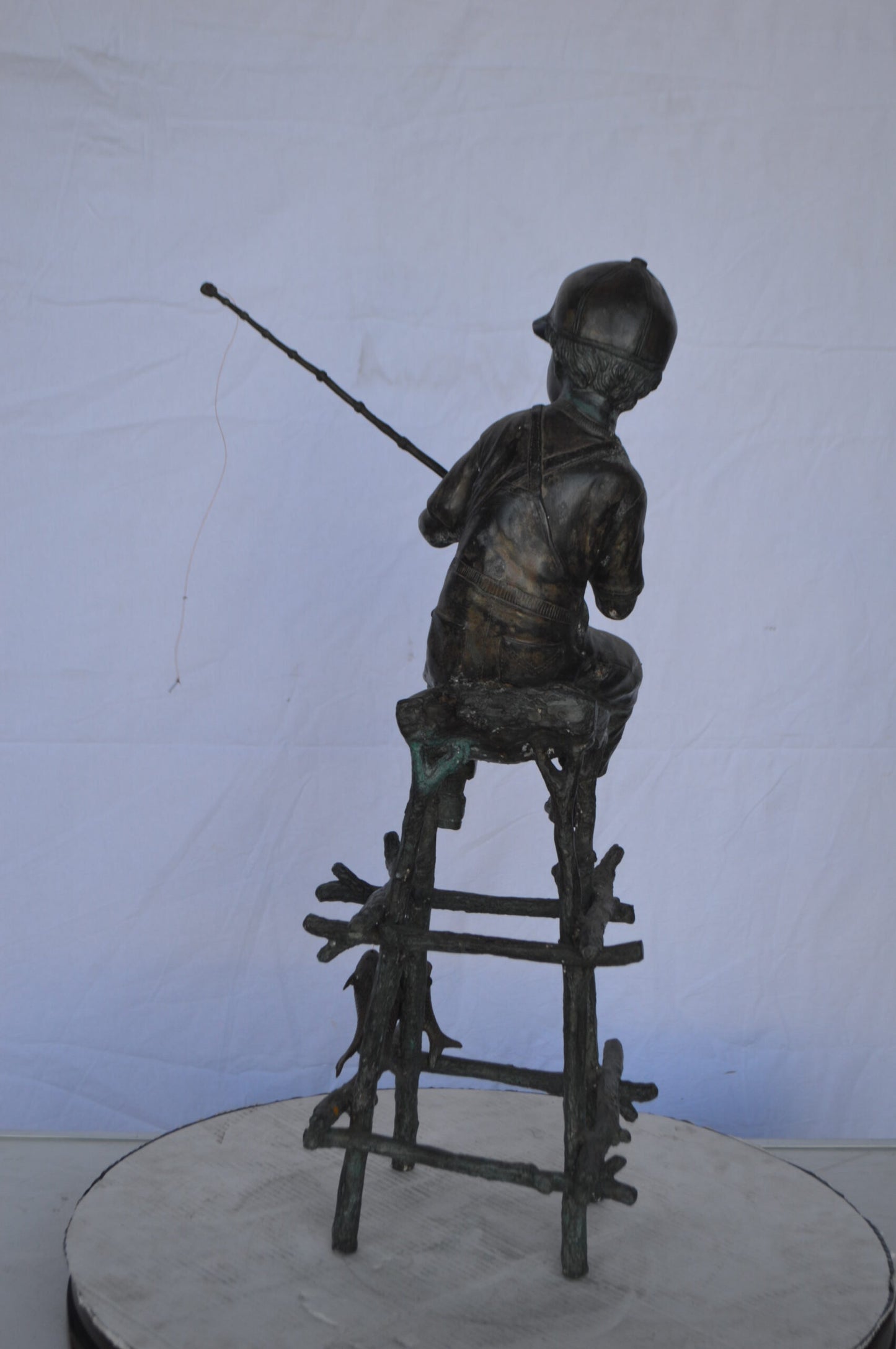 A Boy on a high Chair Fishing Bronze Statue - Size: 16"L x 14"W x 28"H.