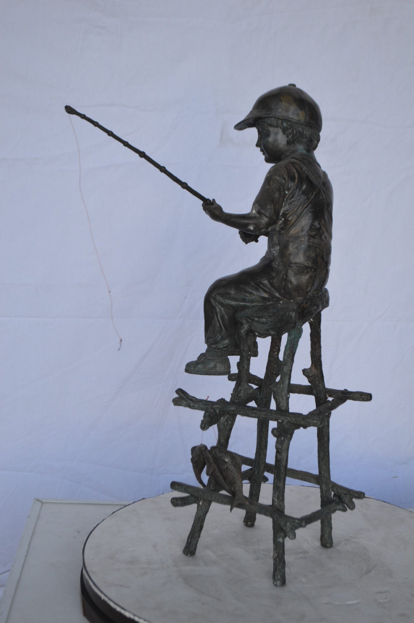A Boy on a high Chair Fishing Bronze Statue - Size: 16"L x 14"W x 28"H.