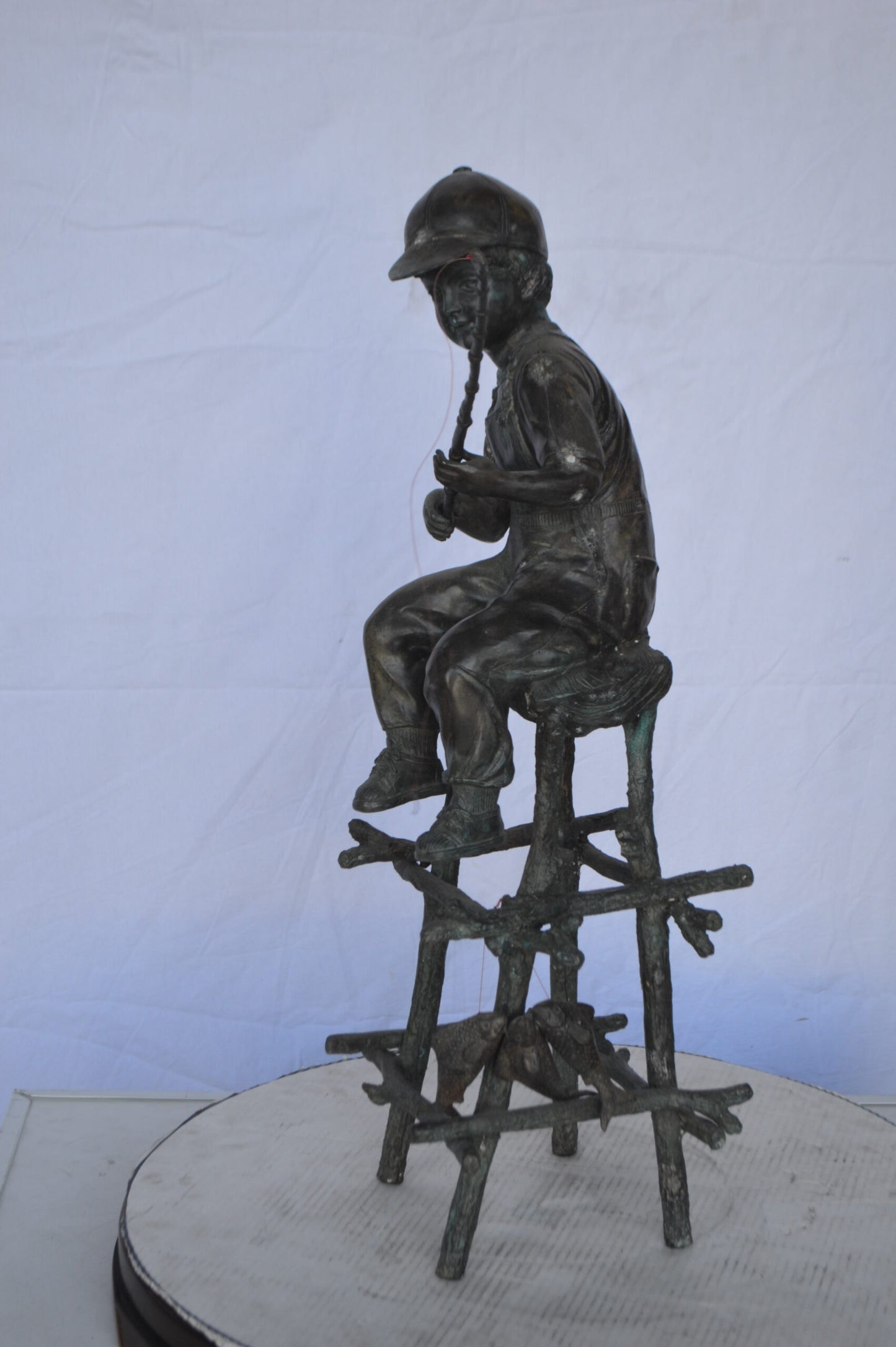 A Boy on a high Chair Fishing Bronze Statue - Size: 16"L x 14"W x 28"H.