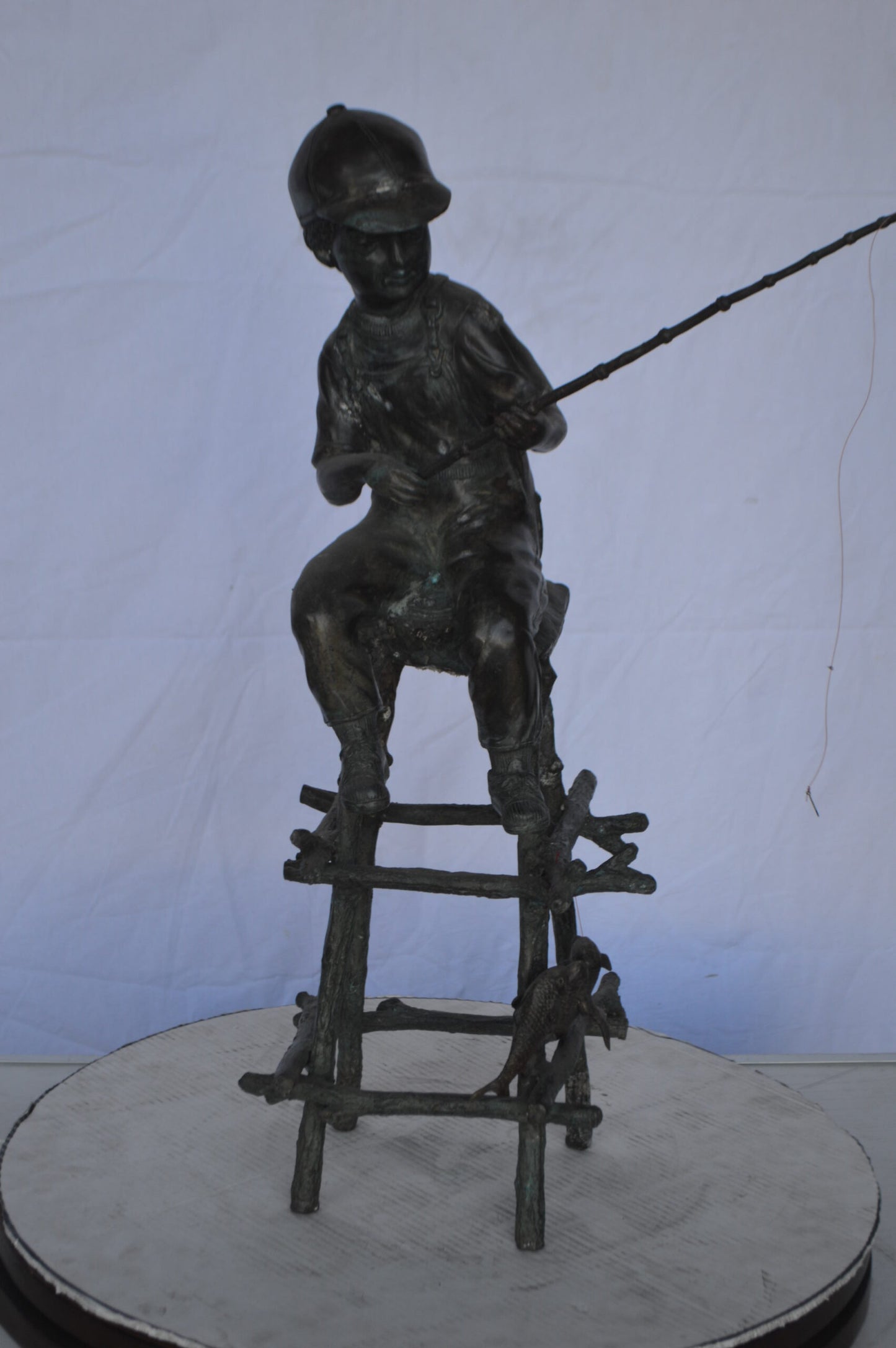 A Boy on a high Chair Fishing Bronze Statue - Size: 16"L x 14"W x 28"H.