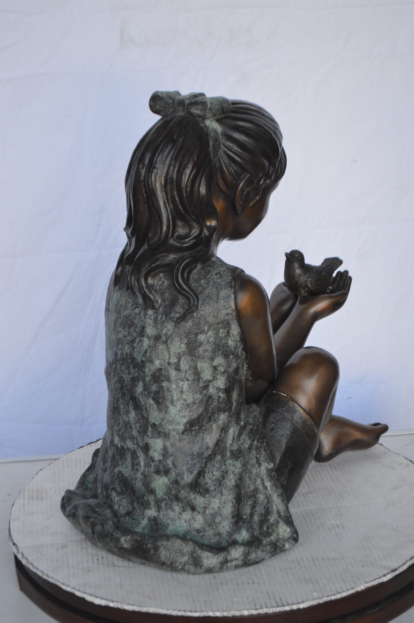 Girl Knees Up Holding a Bird Bronze Statue - Size: 22"L x 14"W x 24"H.