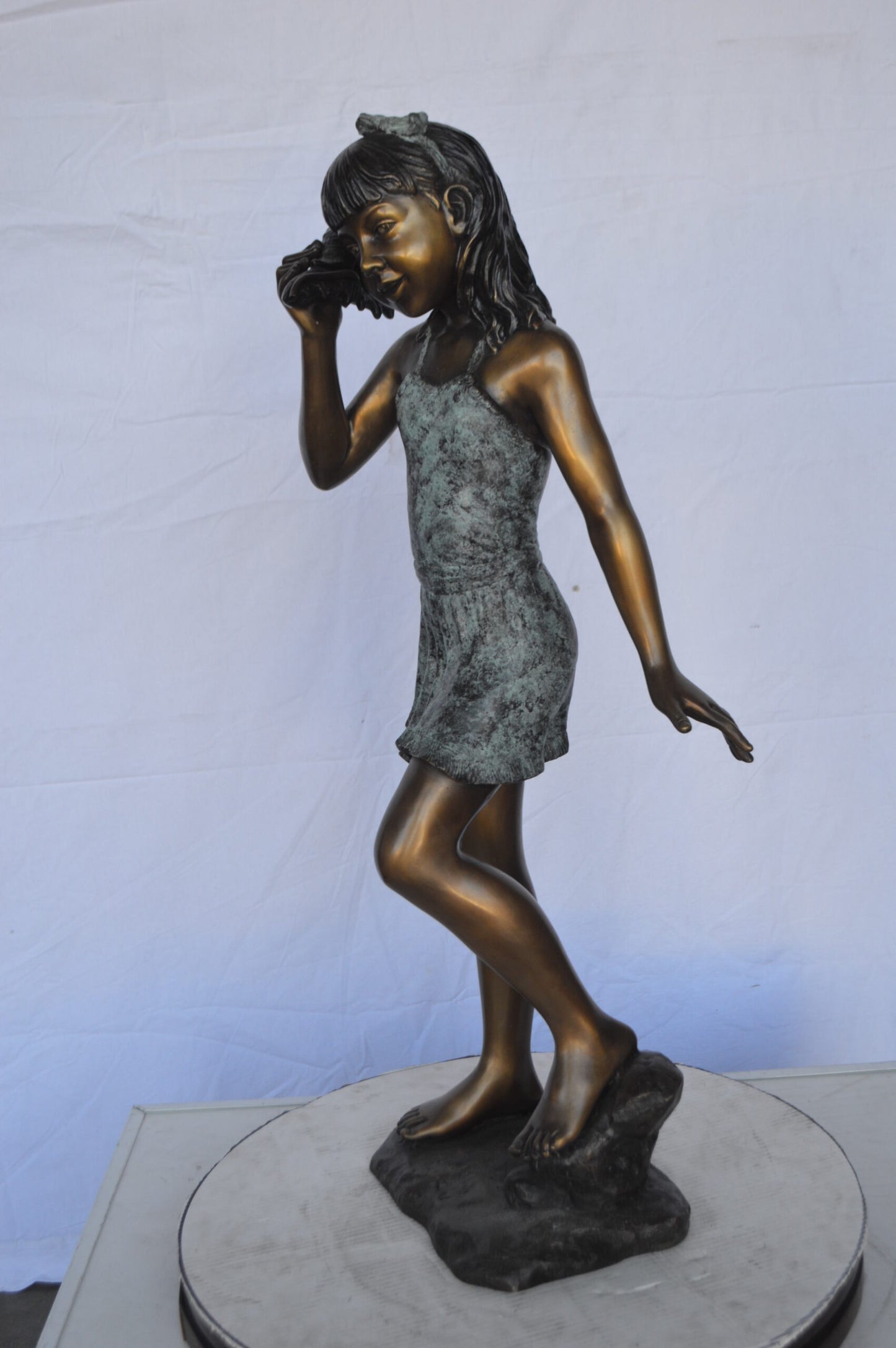 Standing Girl Listening to a Shell Bronze Statue - Size: 16"L x 12"W x 37"H.