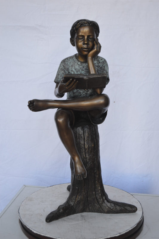 Boy Sitting on a Stump Reading a Book -  Size: 18"L x 20"W x 35"H.