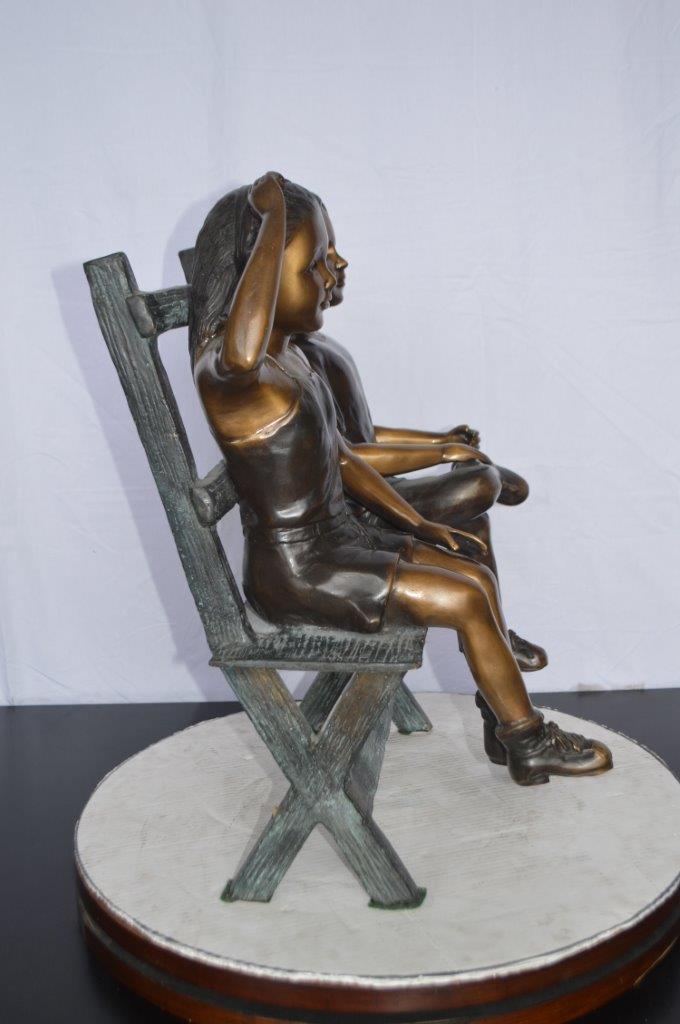 Two Kids Sitting On a Bench Bronze Statue - Size: 20"L x 18"W x 24"H.