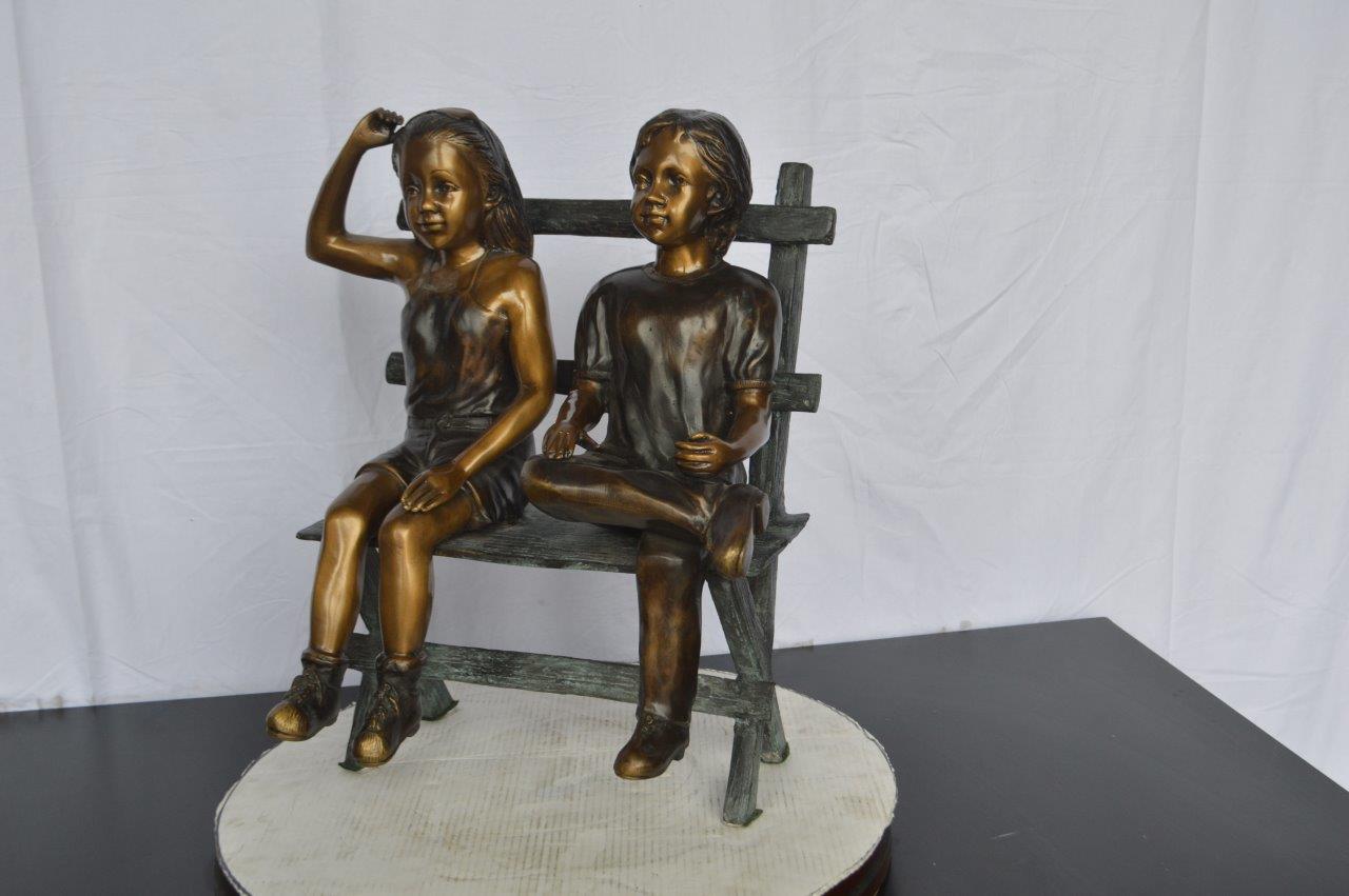 Two Kids Sitting On a Bench Bronze Statue - Size: 20"L x 18"W x 24"H.
