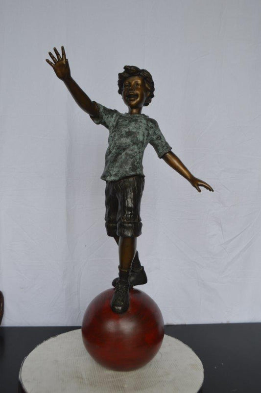 Boy on Ball Bronze Statue - Street Performer - Size: 23"L x 12"W x 39"H.
