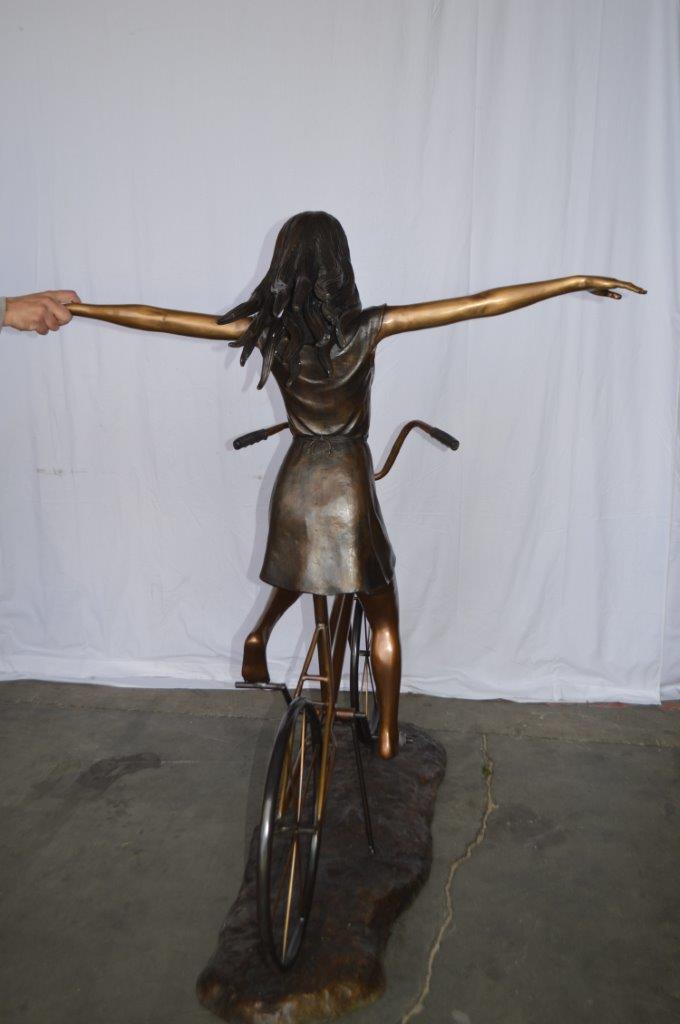 Girl Riding Hands Free life Size Bronze Statue - Size: 53"L x 62"W x 61"H.