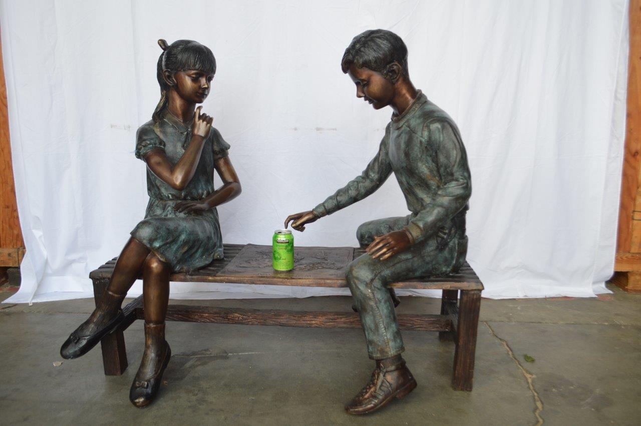 Young Couple Reviewing a World Map Bronze Statue - Size: 32"L x 47"W x 42"H.