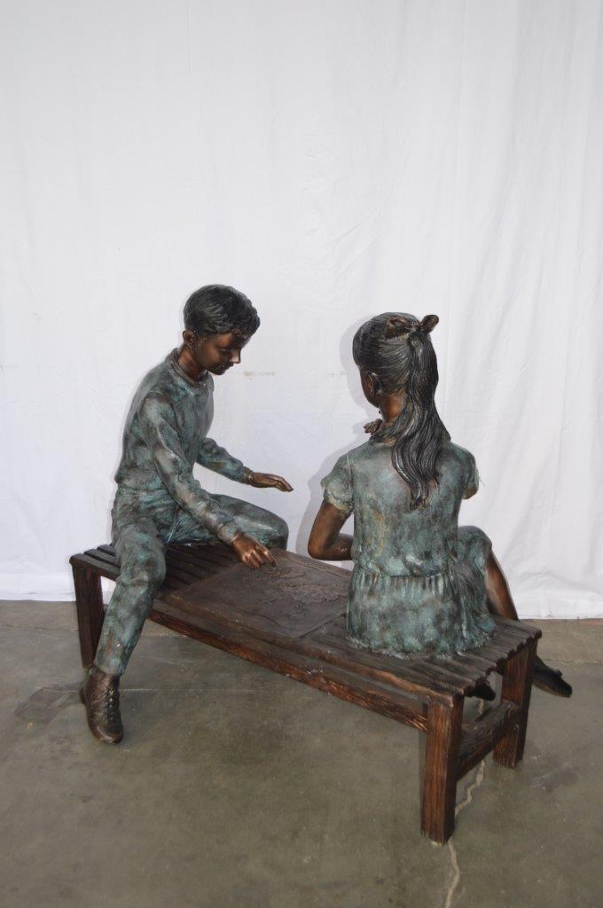 Young Couple Reviewing a World Map Bronze Statue - Size: 32"L x 47"W x 42"H.