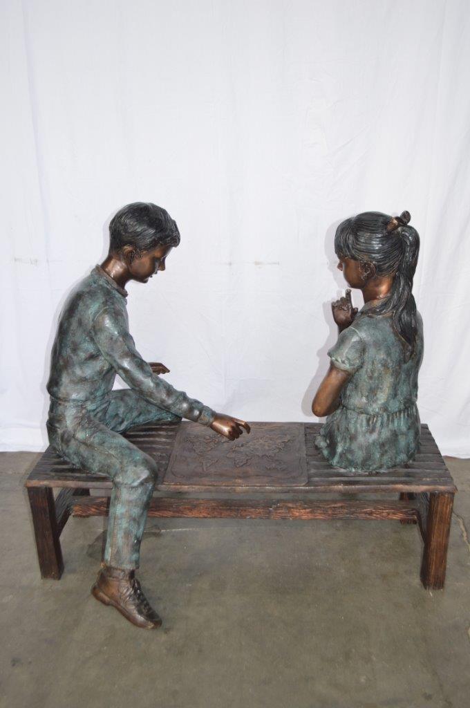 Young Couple Reviewing a World Map Bronze Statue - Size: 32"L x 47"W x 42"H.
