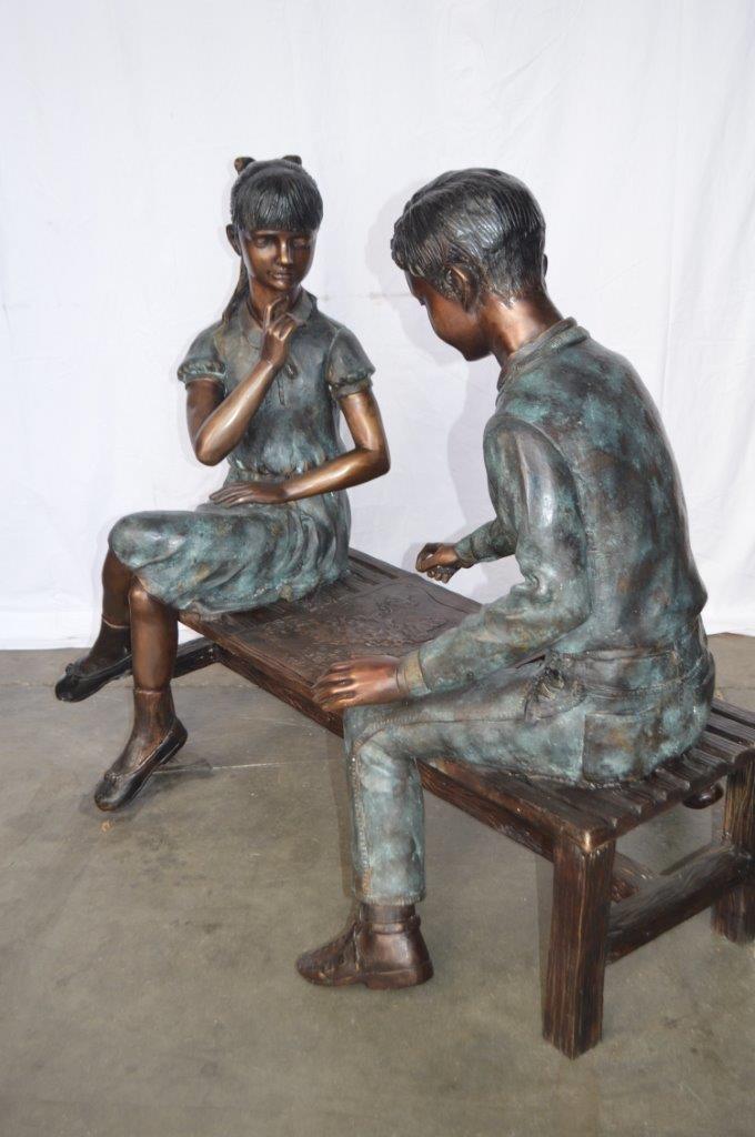 Young Couple Reviewing a World Map Bronze Statue - Size: 32"L x 47"W x 42"H.