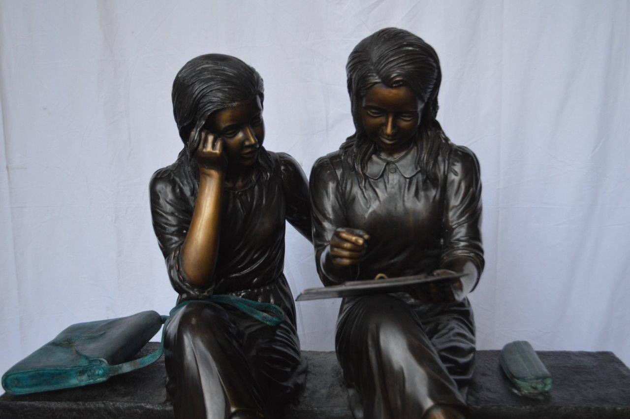 Two Schoolgirls Sitting On a Bench Bronze Statue - Size: 45"L x 24"W x 41"H.