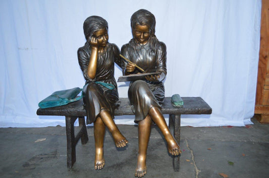 Two Schoolgirls Sitting On a Bench Bronze Statue - Size: 45"L x 24"W x 41"H.