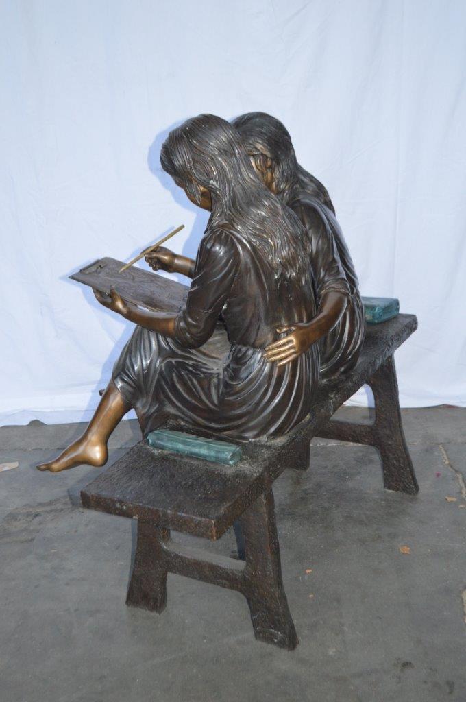 Two Schoolgirls Sitting On a Bench Bronze Statue - Size: 45"L x 24"W x 41"H.