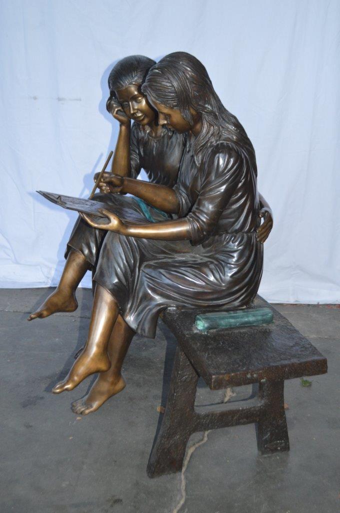 Two Schoolgirls Sitting On a Bench Bronze Statue - Size: 45"L x 24"W x 41"H.