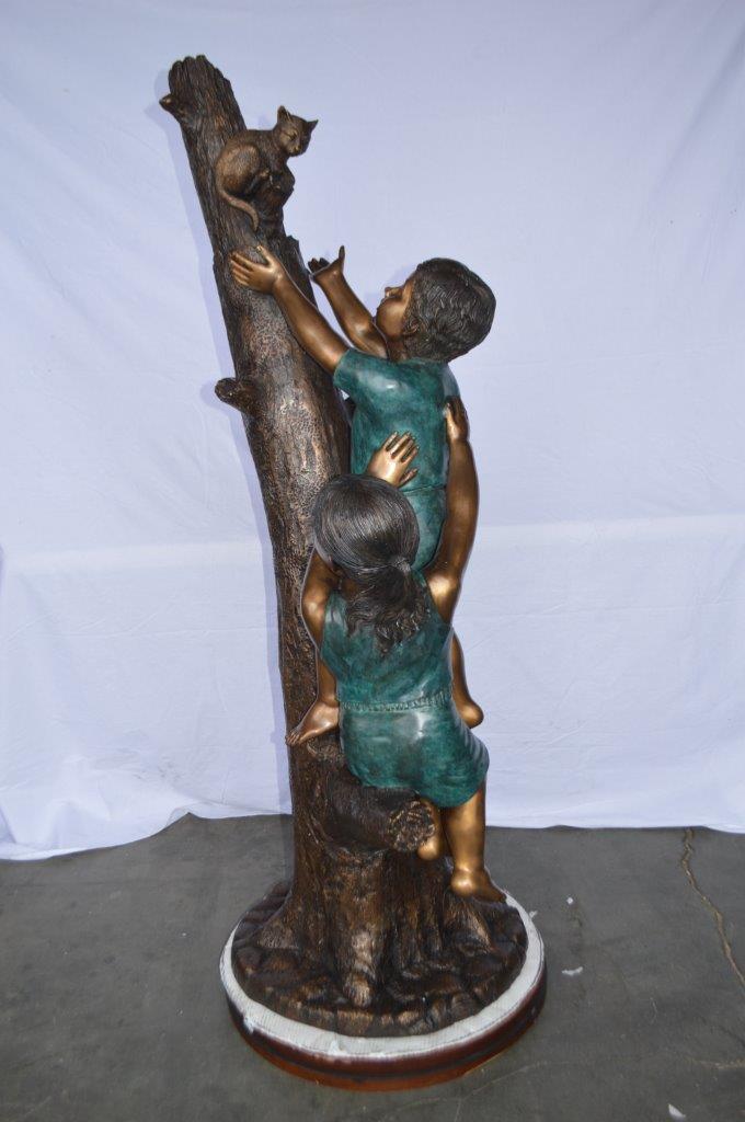 Children reaching up tree for a cat bronze statue - Size: 24"L x 21"W x 64"H.