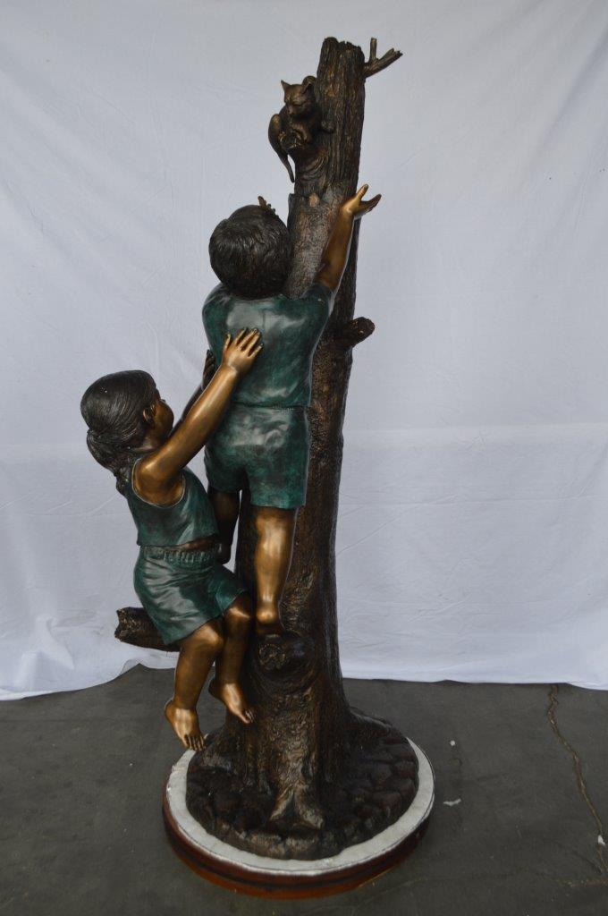 Children reaching up tree for a cat bronze statue - Size: 24"L x 21"W x 64"H.