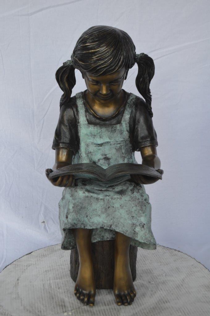 Young girl sitting and reading book bronze statue -  Size: 16"L x 12"W x 27"H.