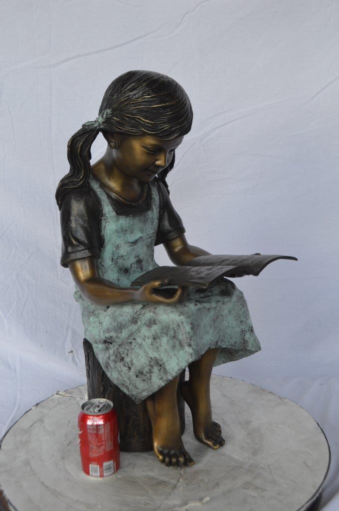 Young girl sitting and reading book bronze statue -  Size: 16"L x 12"W x 27"H.