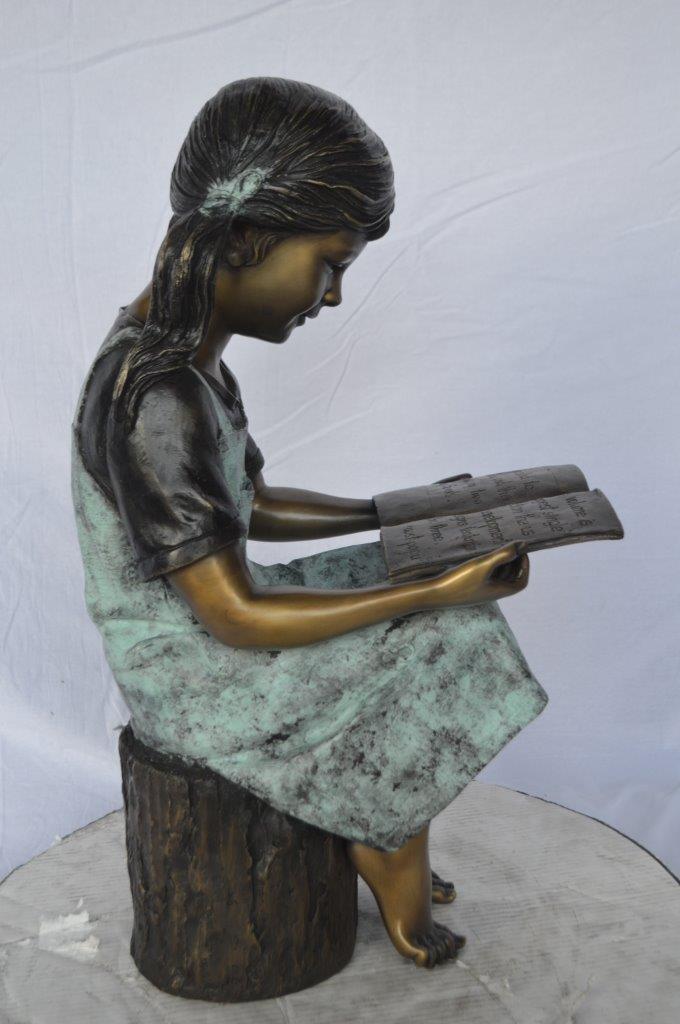 Young girl sitting and reading book bronze statue - Size: 16"L x 12"W x 27"H.