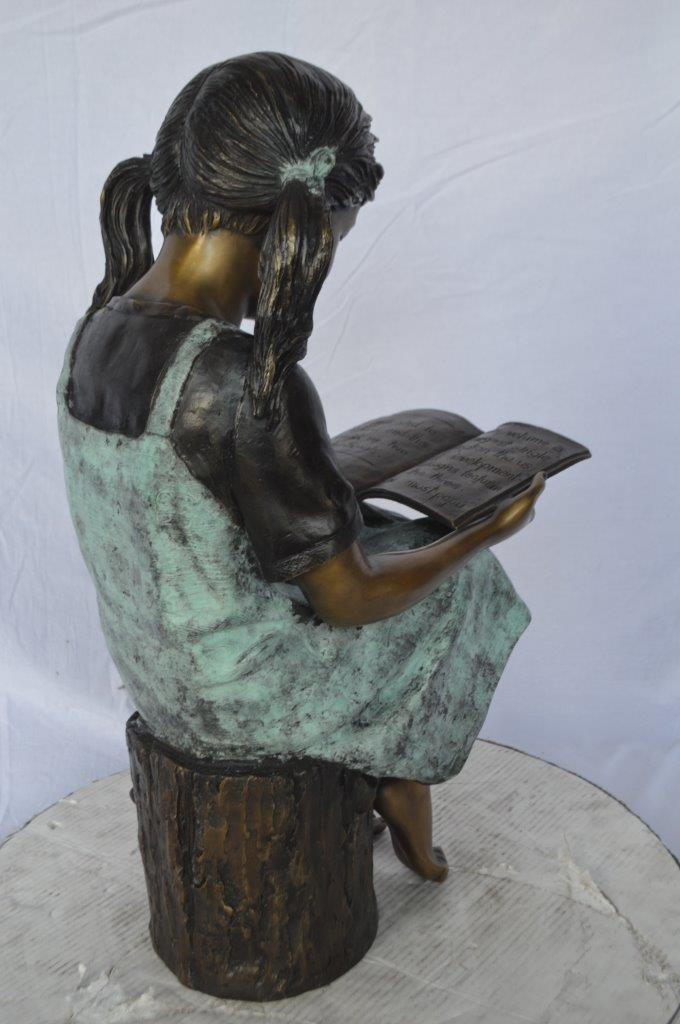 Young girl sitting and reading book bronze statue -  Size: 16"L x 12"W x 27"H.