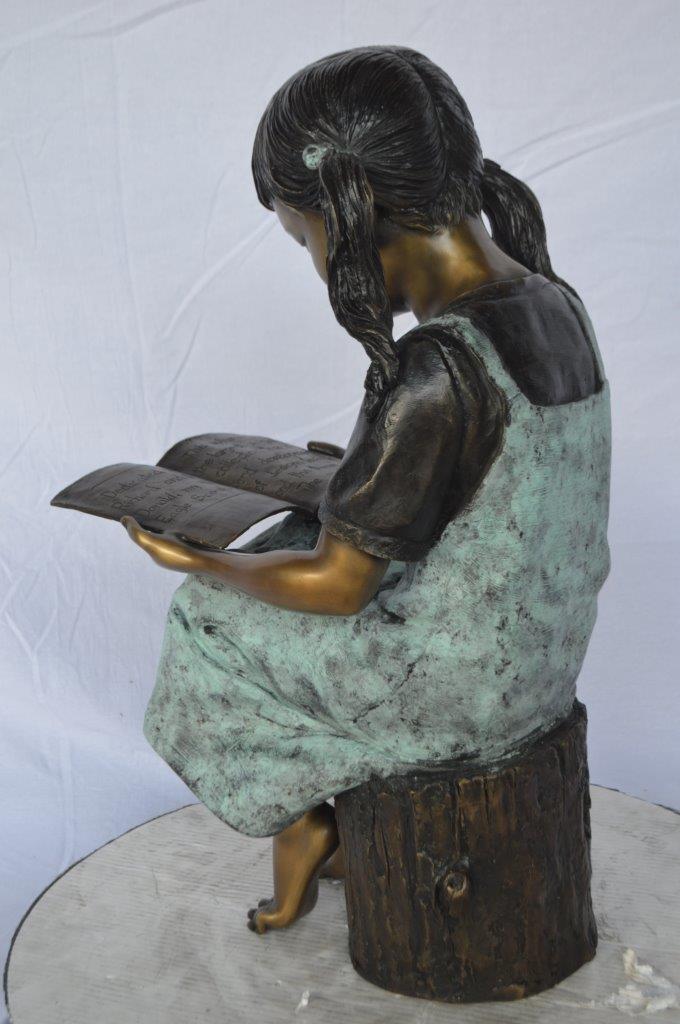 Young girl sitting and reading book bronze statue - Size: 16"L x 12"W x 27"H.