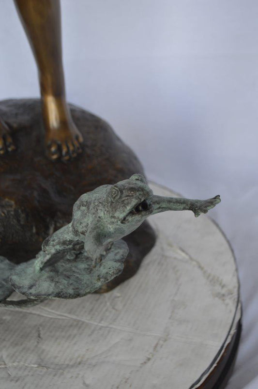 Girl looking at frog jumping bronze fountain - Size: 21"L x 15"W x 38"H.