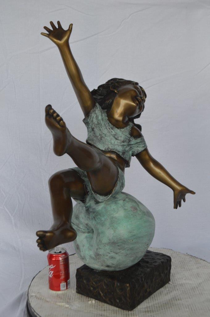 Girl having fun on apple bronze statue - Size: 22"L x 9"W x 31"H.