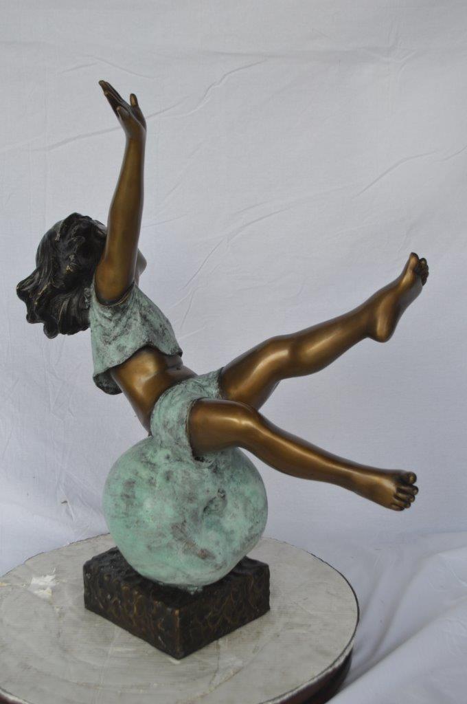 Girl having fun on apple bronze statue - Size: 22"L x 9"W x 31"H.