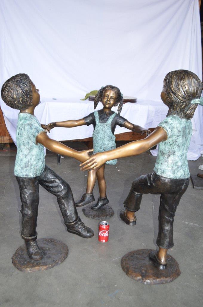 Three children happily holding hands bronze statue - Size: 31"L x 19"W x 41"H.