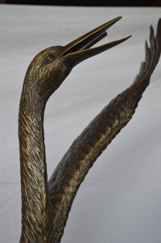 Crane standing on a stone bronze statue - Size: 28"L x 32"W x 49"H.